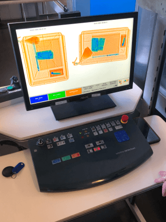 Poste de travail d'opérateur de scanner affichant deux vues 2D de bagages à l'écran, avec un clavier physique de contrôle